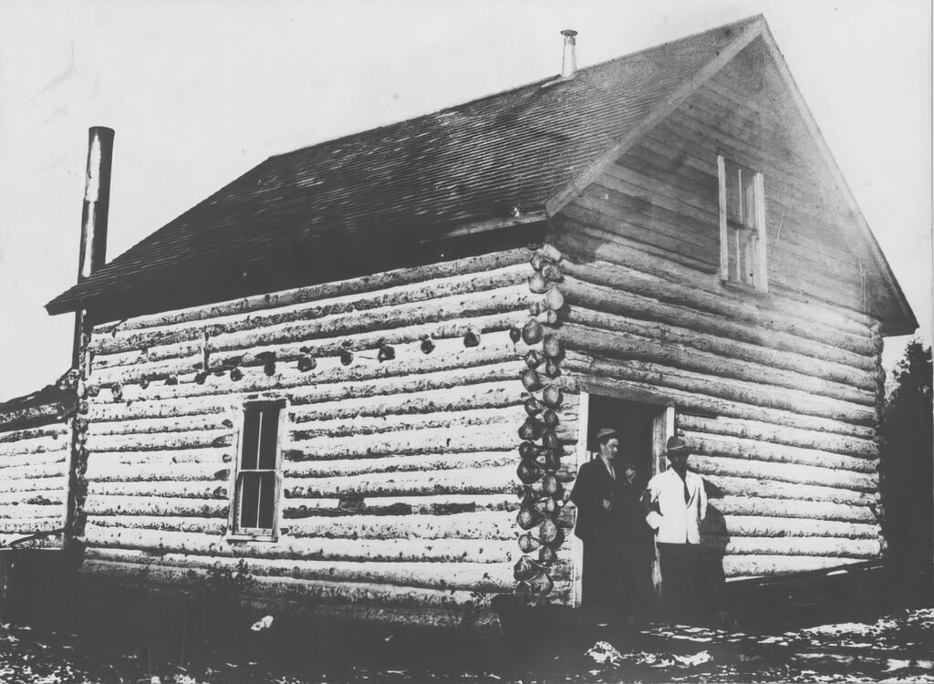Black and white photo of the creamery. Two people stand in the doorway.
